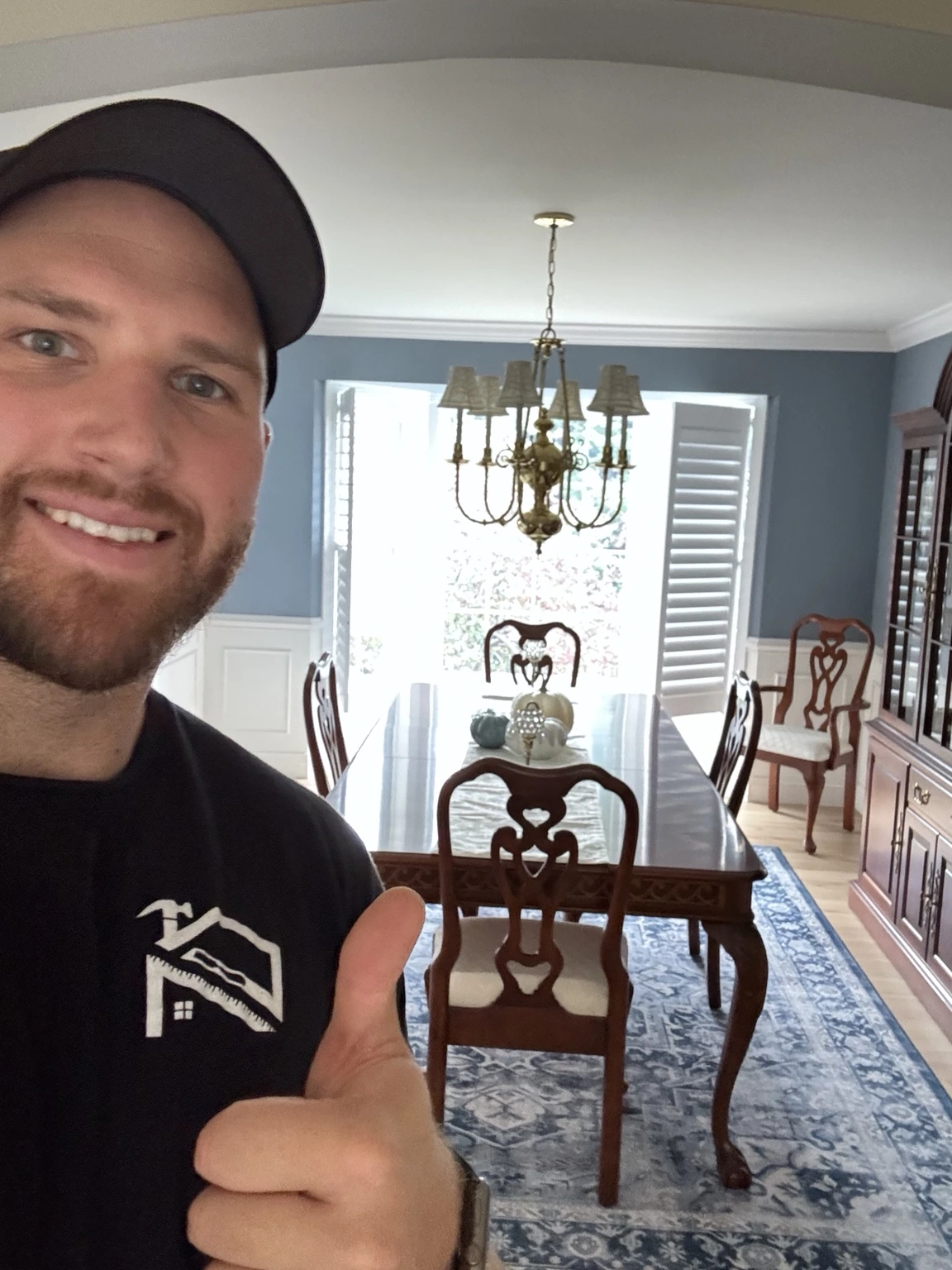 Gary smiling in his branded work shirt in a client’s dining room