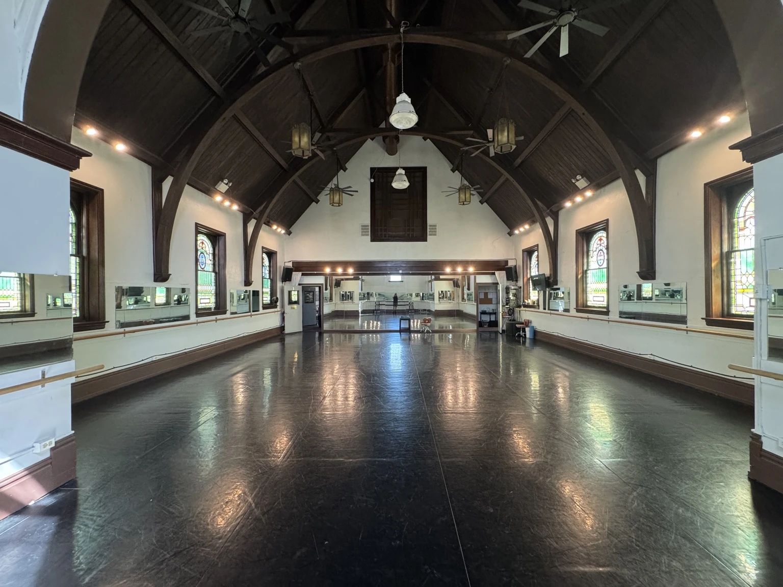 Large finished interior with dark flooring and a tall beamed ceiling